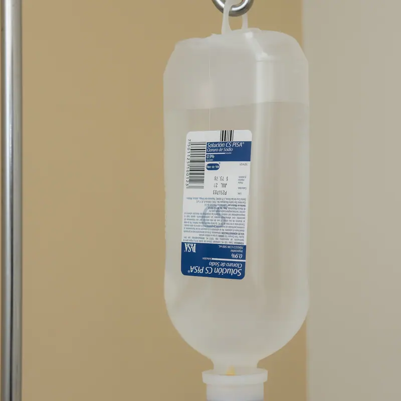 Solución intravenosa suspendida en el portasueros de una sala de infusión